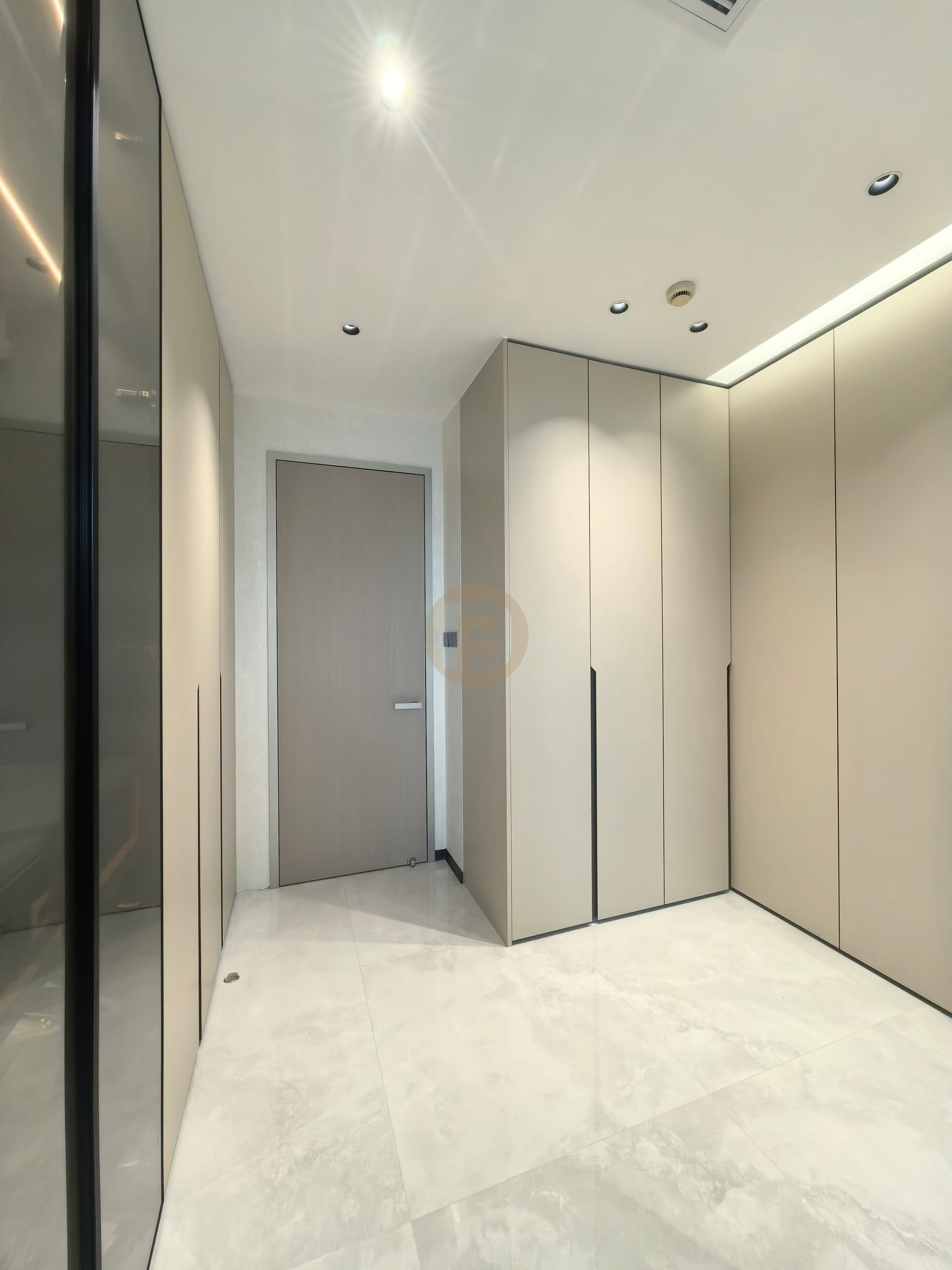 Dressing corridor with champagne stainless steel wardrobes and a smoked-glass partition