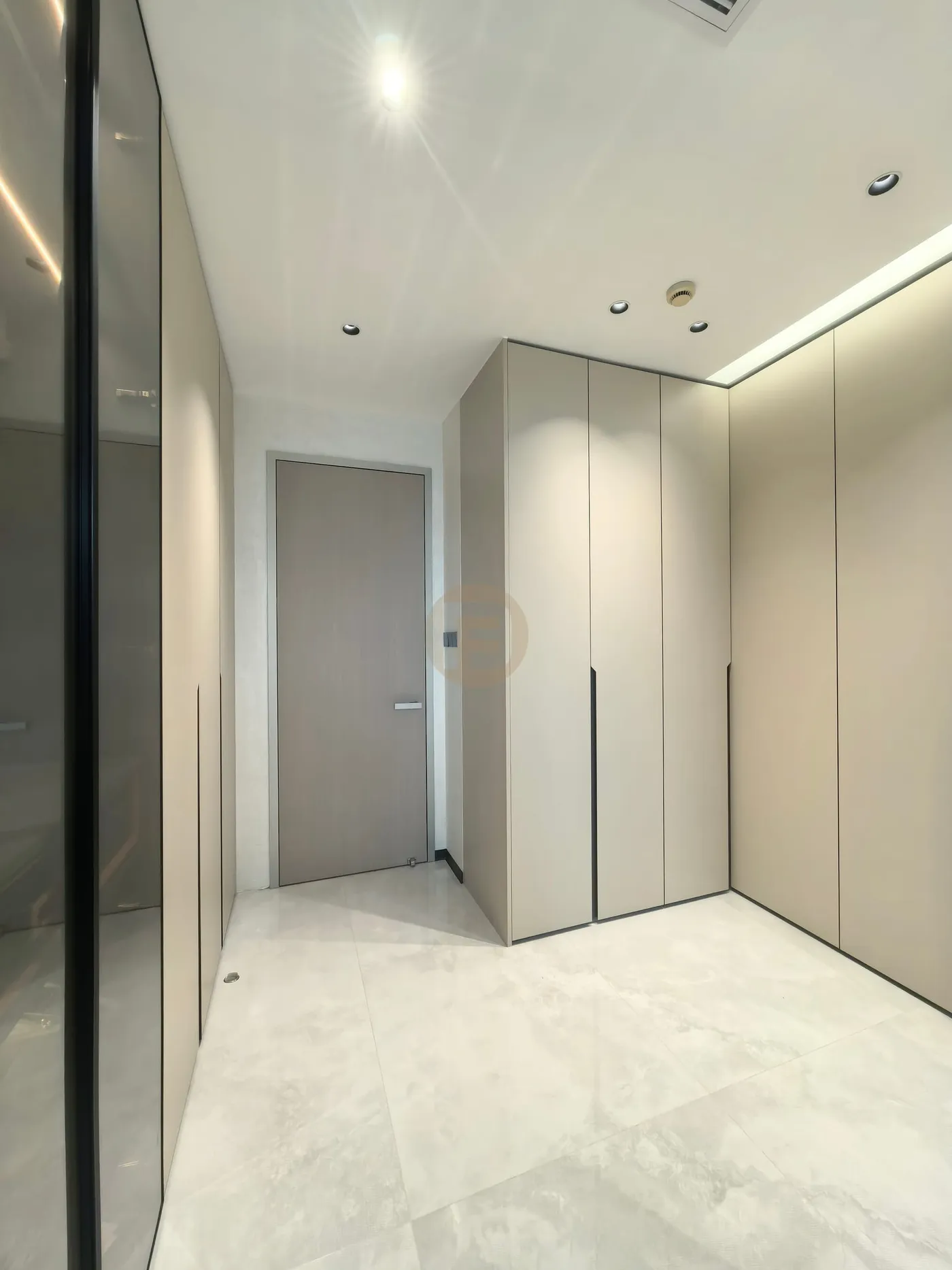 Dressing corridor with champagne stainless steel wardrobes and a smoked-glass partition
