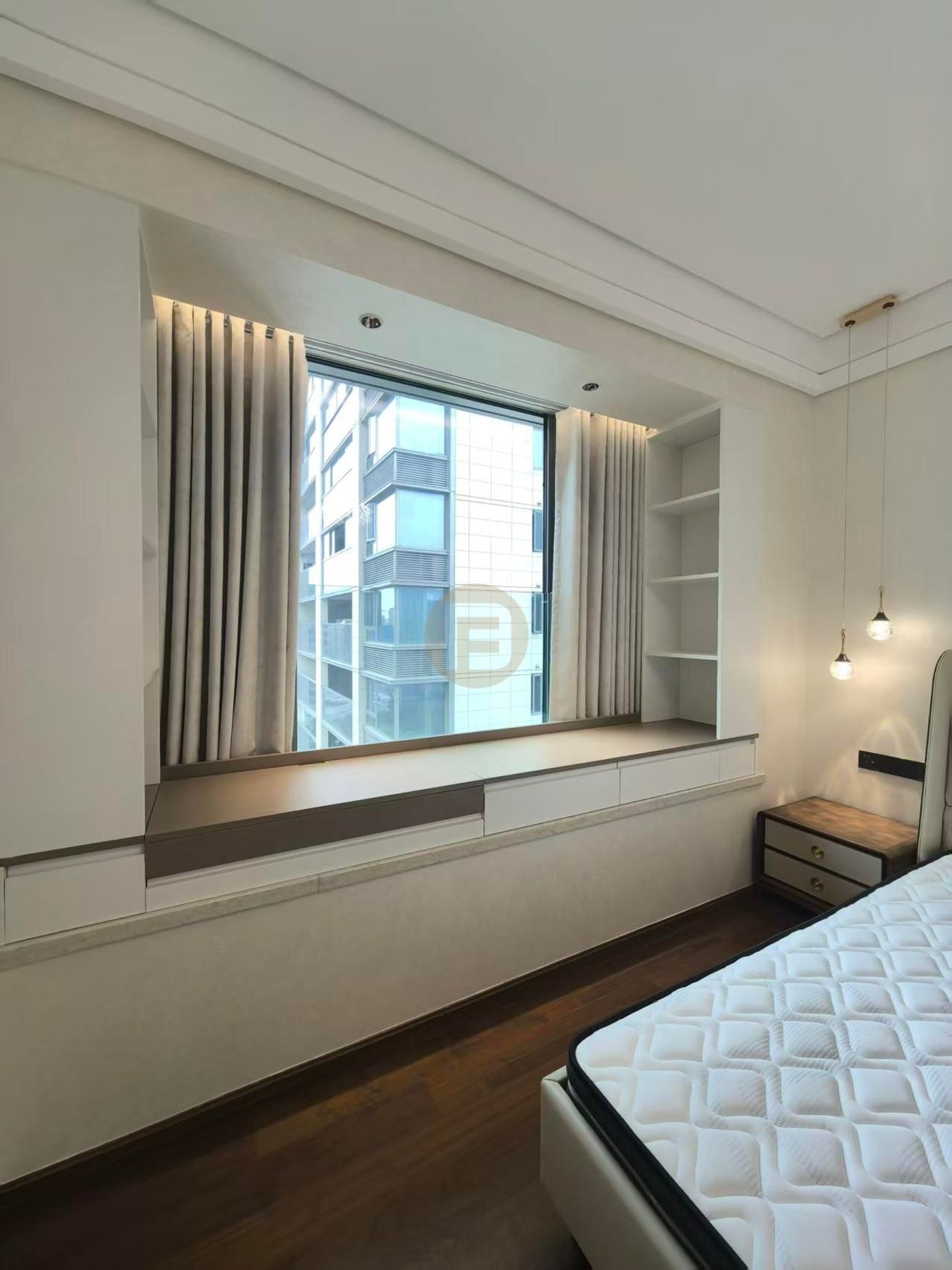 Bedroom bay window with built-in stainless steel storage bench, shelving niche and layered curtains