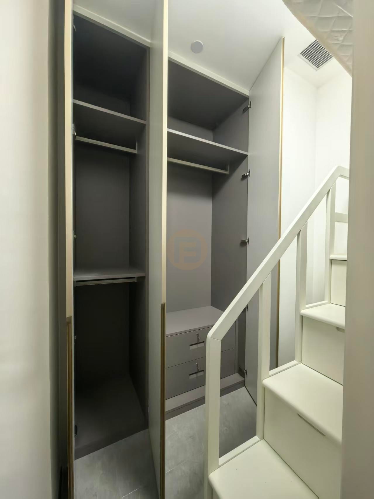 Open wardrobe bay in warm grey stainless steel with shelves, hanging rails and integrated drawers