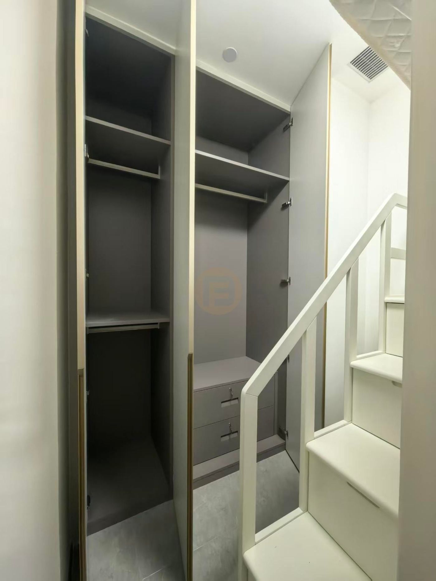 Open wardrobe bay in warm grey stainless steel with shelves, hanging rails and integrated drawers