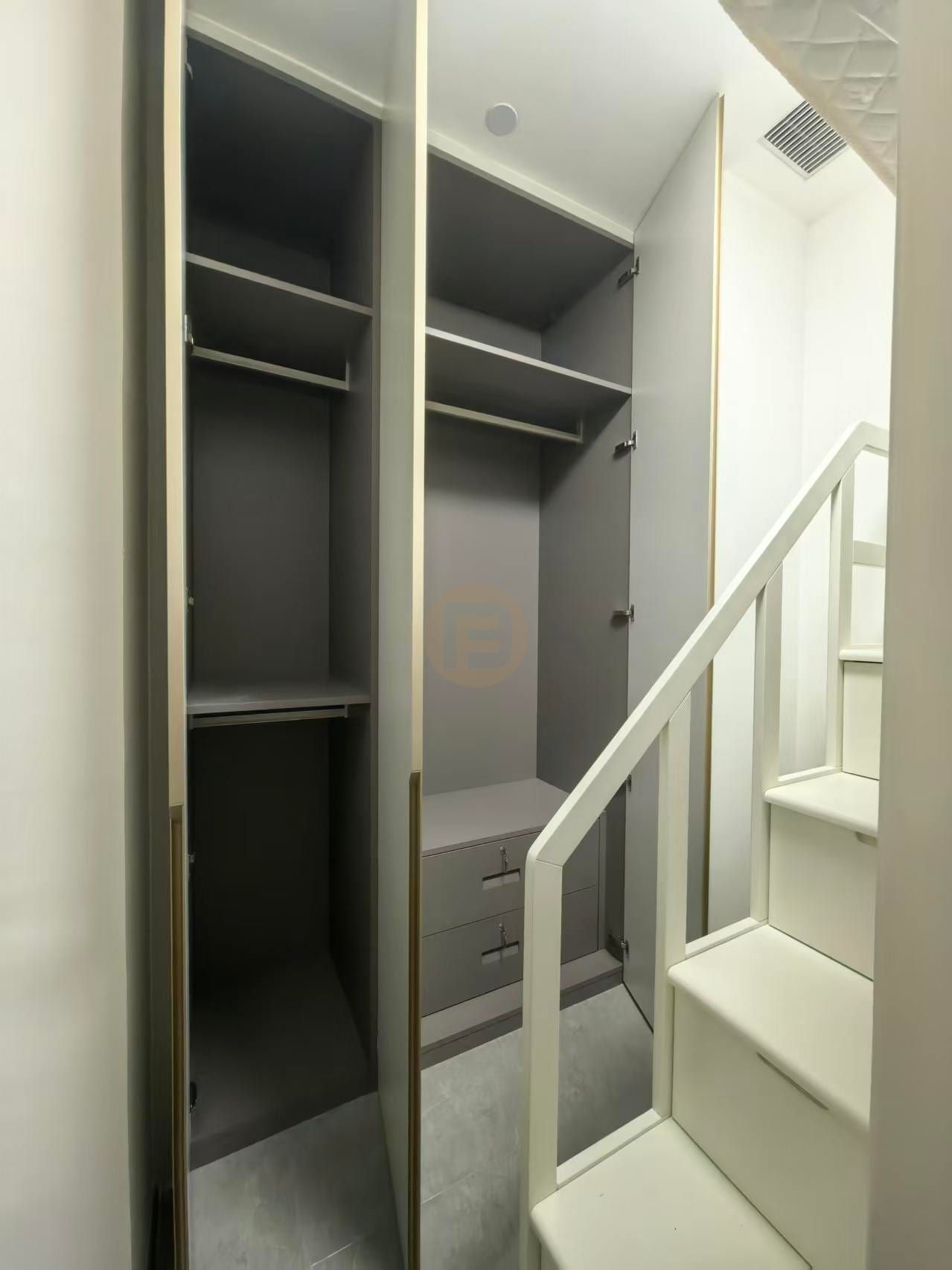 Open wardrobe bay in warm grey stainless steel with shelves, hanging rails and integrated drawers