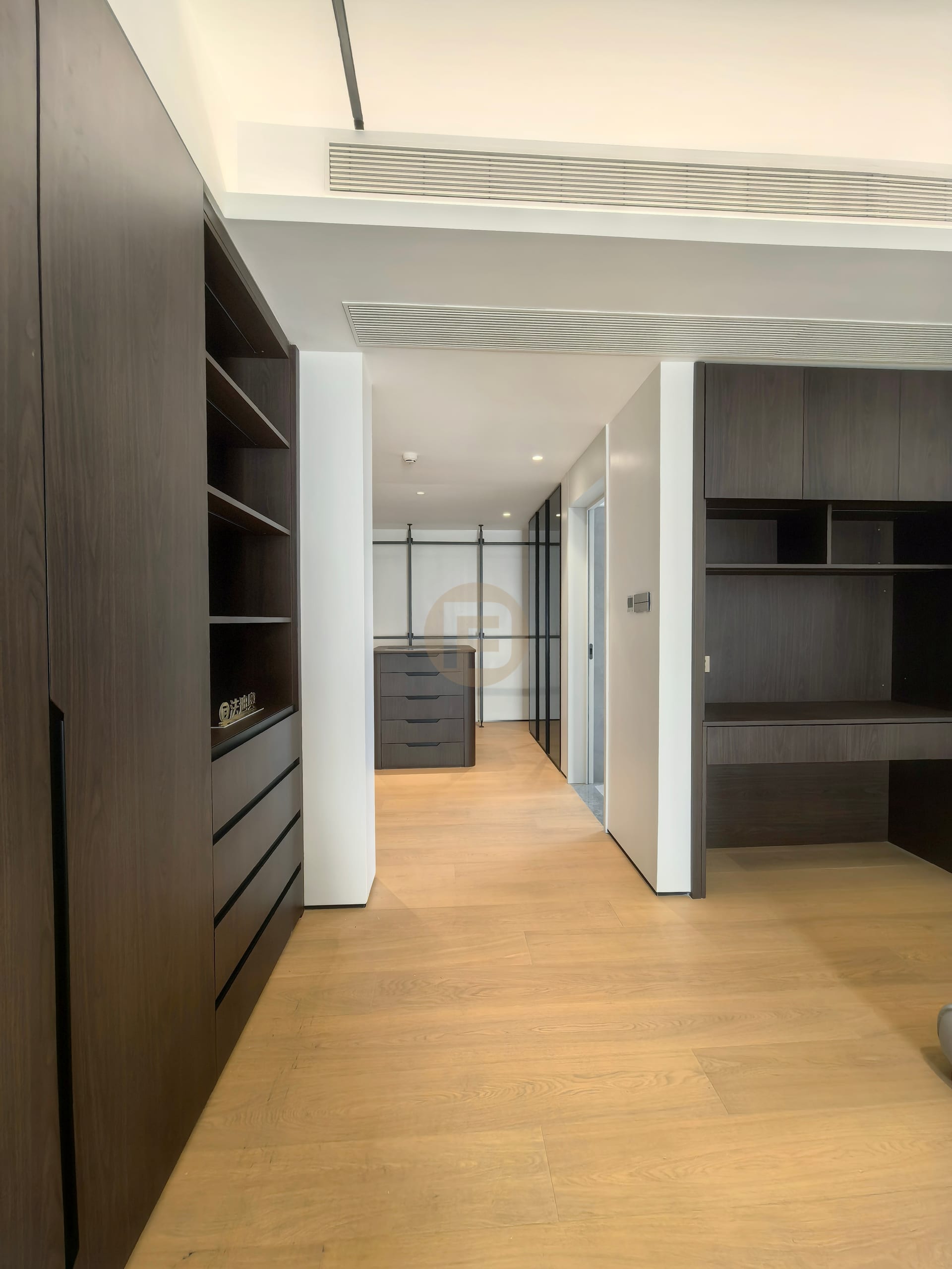 Dark timber-look study storage and desk bay looking through to the dressing room island