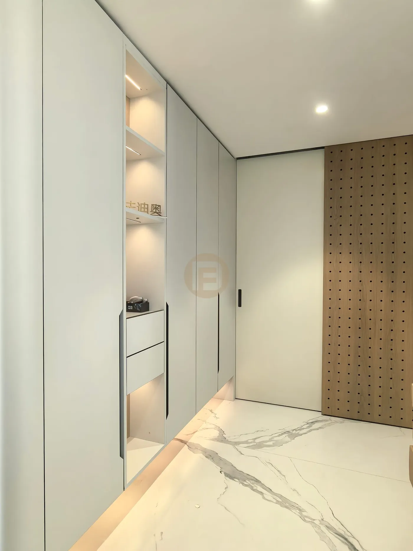 Pale entry cabinetry with a lit display niche and sliding oak pegboard screen