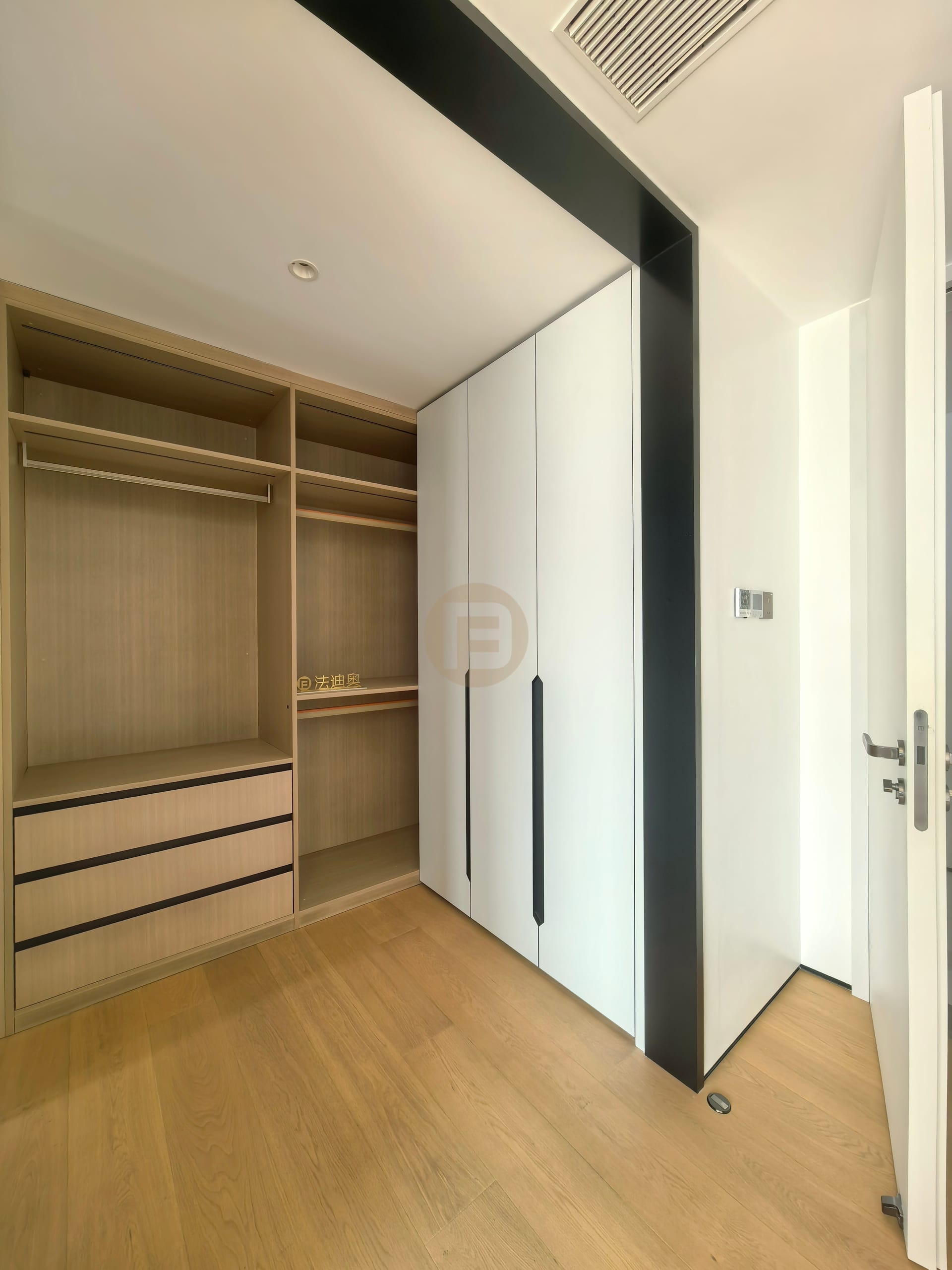 Bedroom wardrobe with open oak interior beside white doors and slim black handle reveals