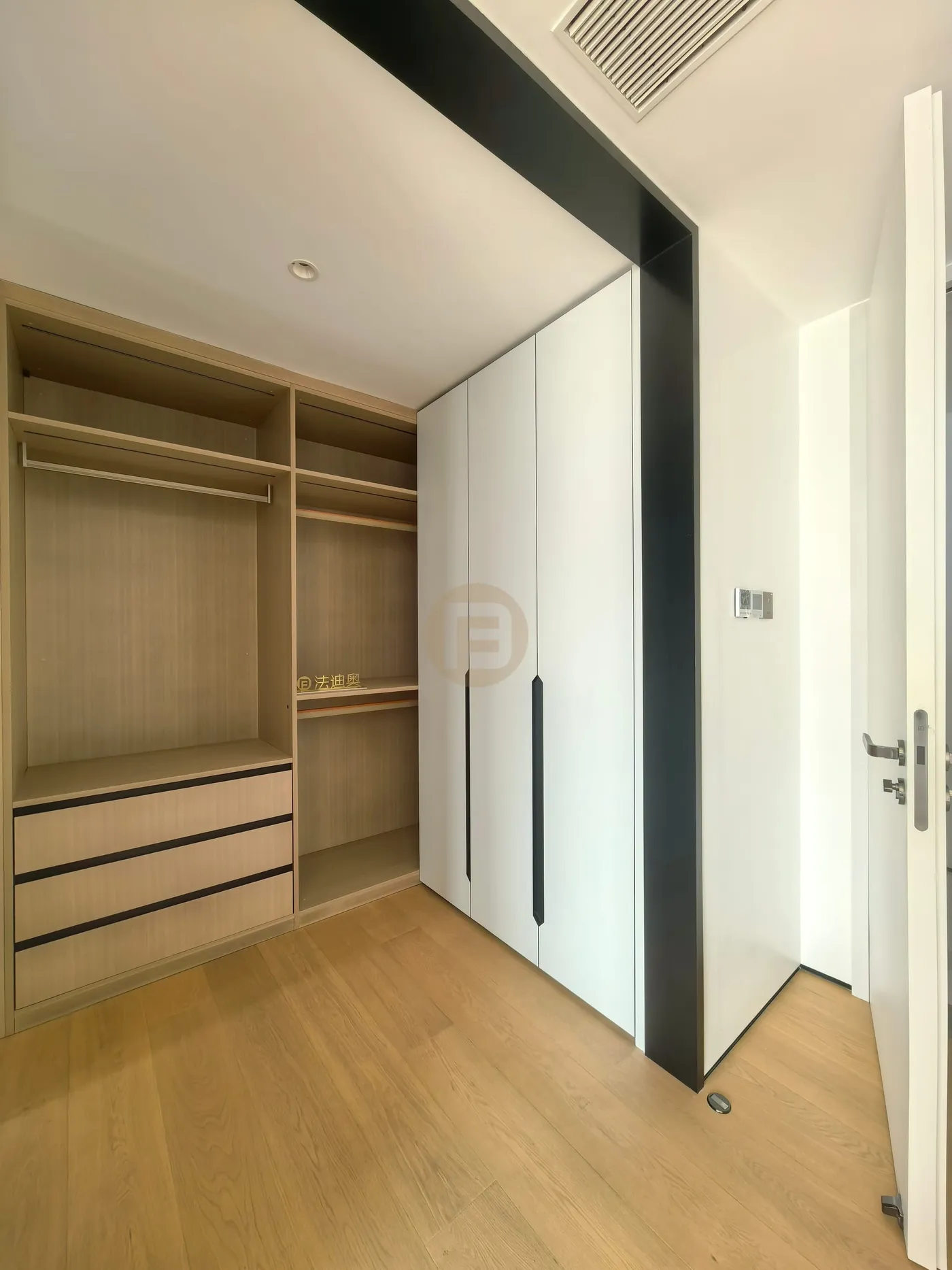 Bedroom wardrobe with open oak interior beside white doors and slim black handle reveals