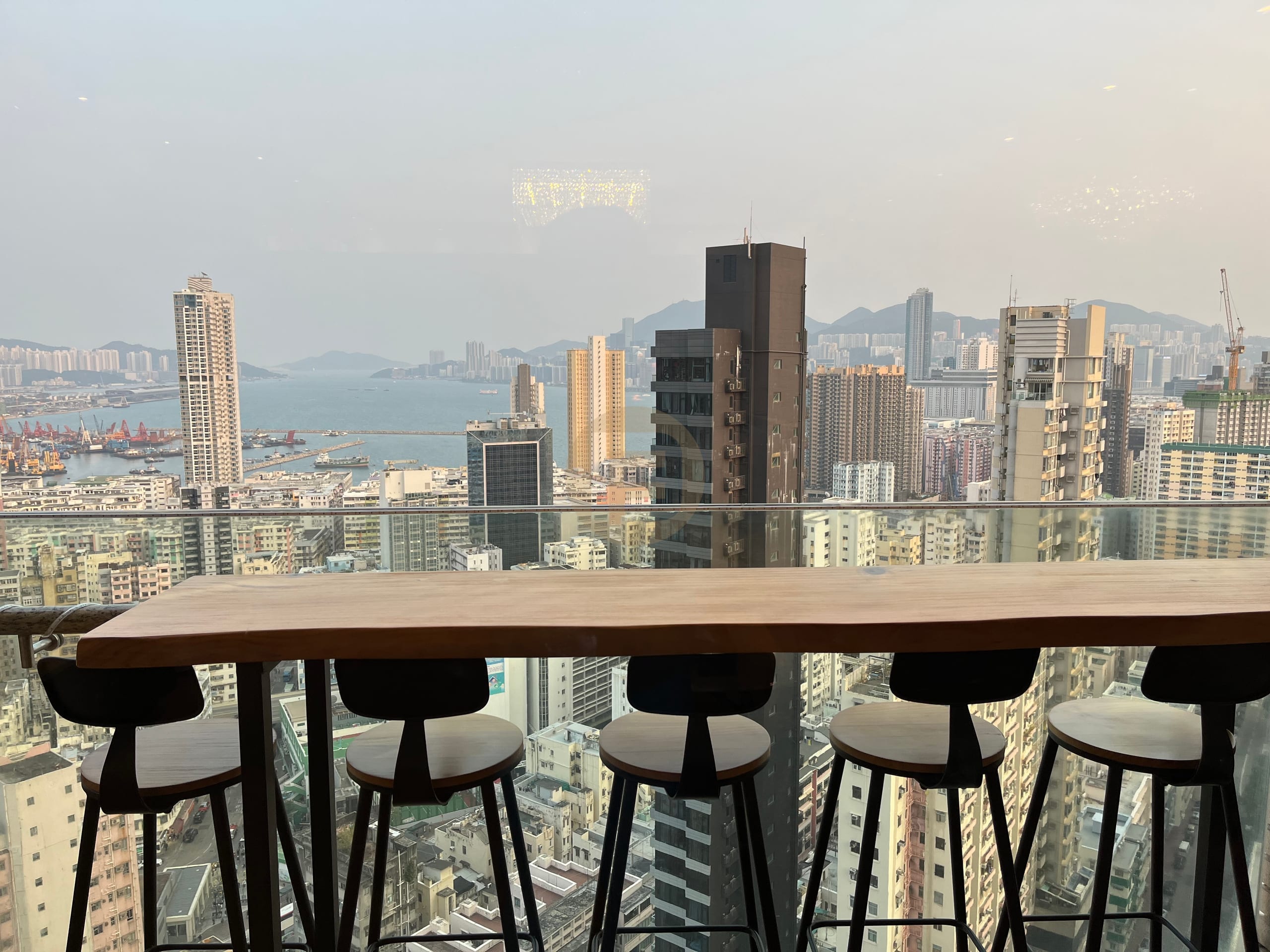 Timber window bar counter with stools overlooking the Hong Kong skyline and harbour