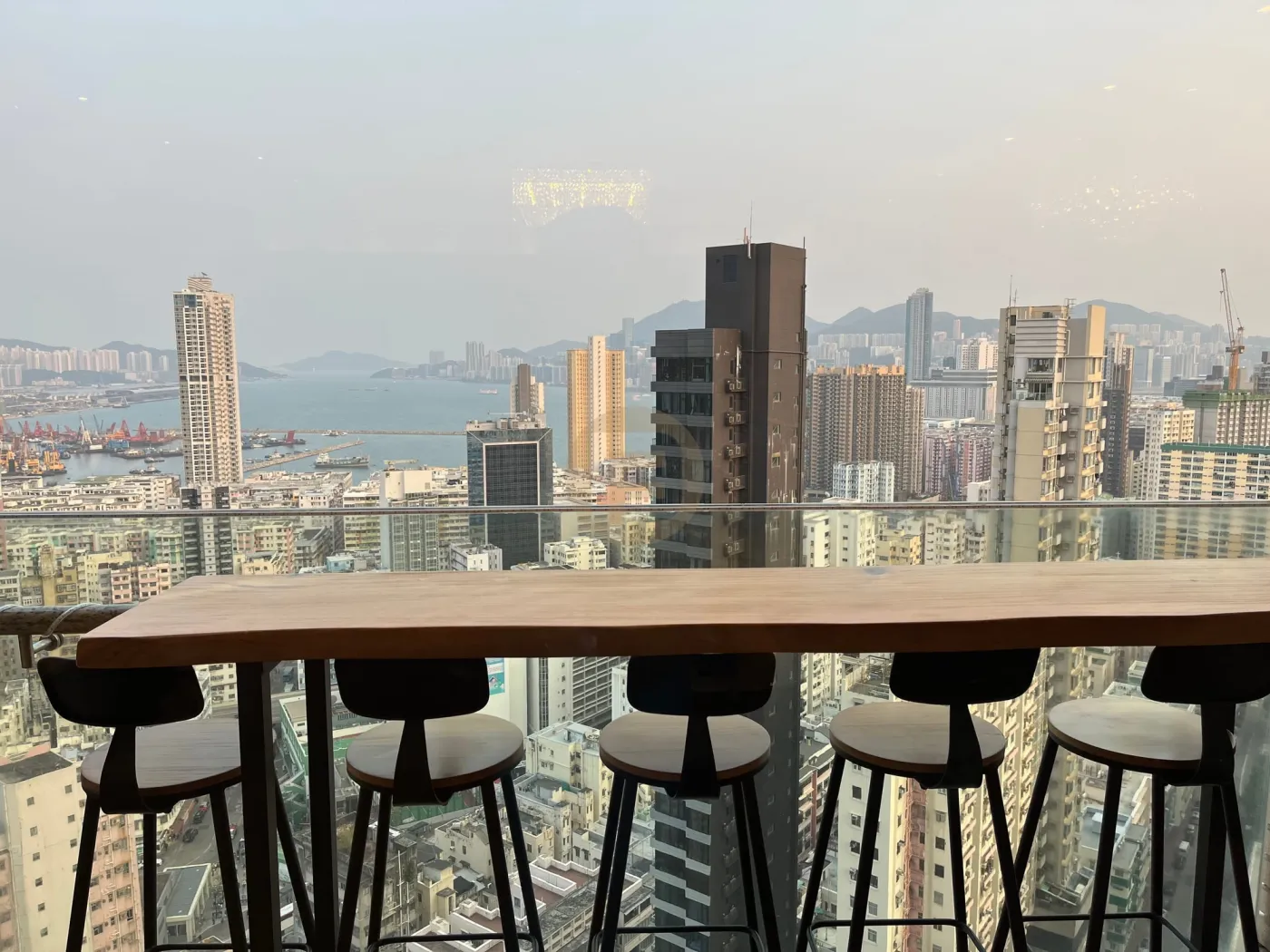 Timber window bar counter with stools overlooking the Hong Kong skyline and harbour