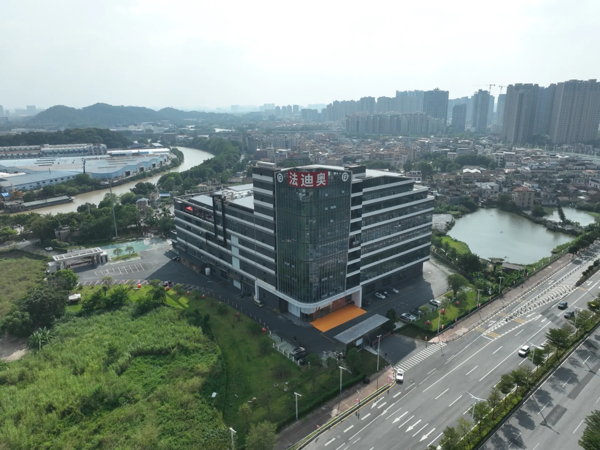 Aerial view of Fadior's Foshan factory campus beside the surrounding urban landscape.