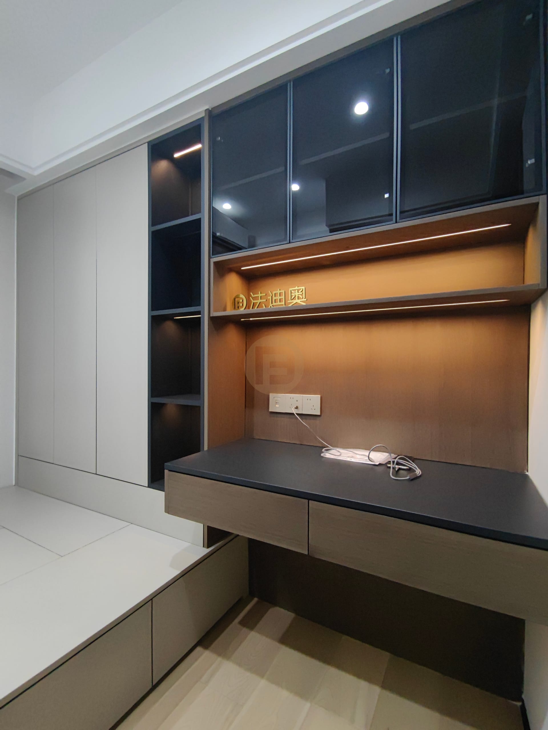 Tatami study with floating dark desk, glass-front upper cabinets and lit display shelving