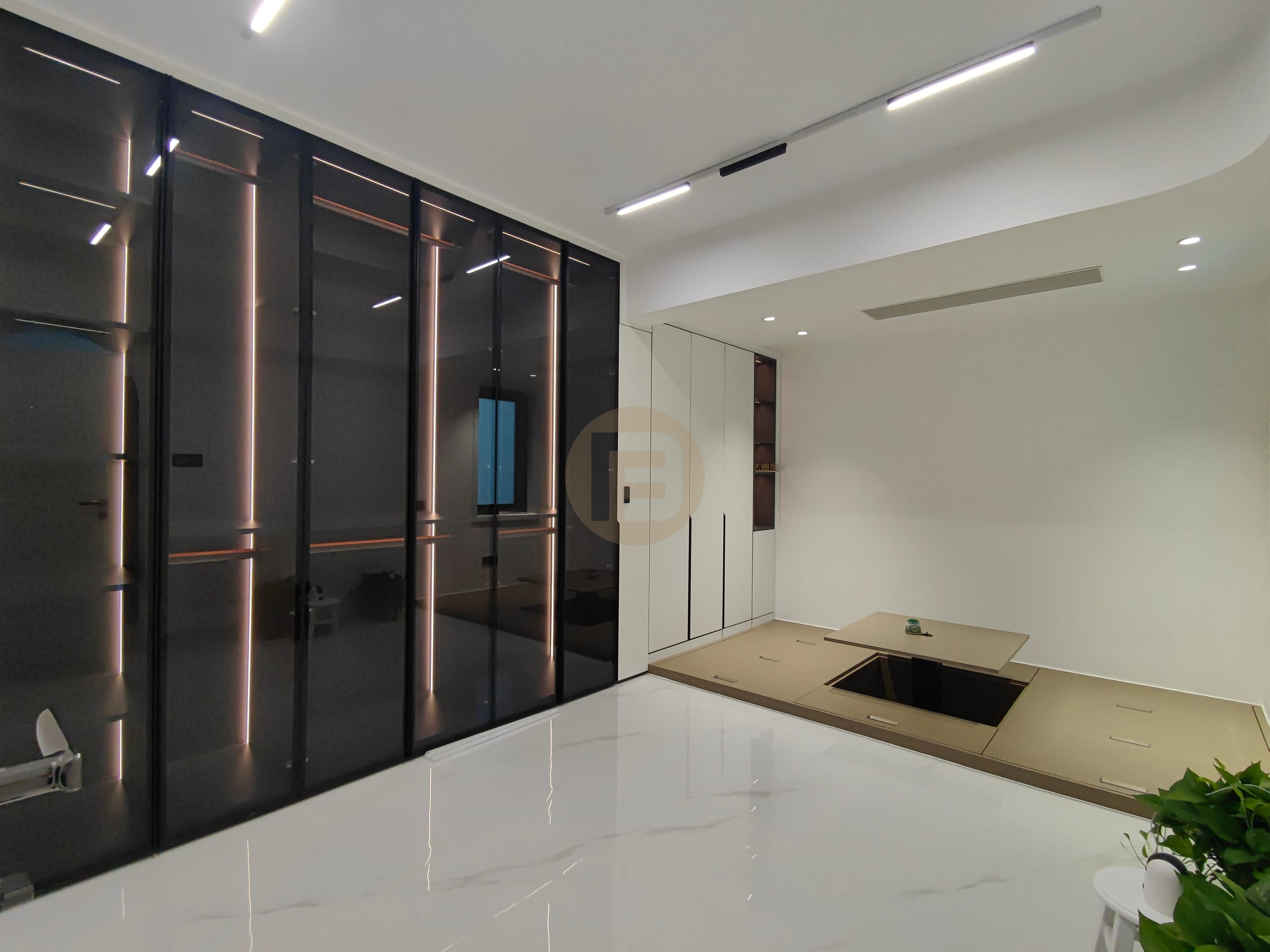 Smoked-glass wardrobe wall with LED edge lighting beside the raised tatami platform