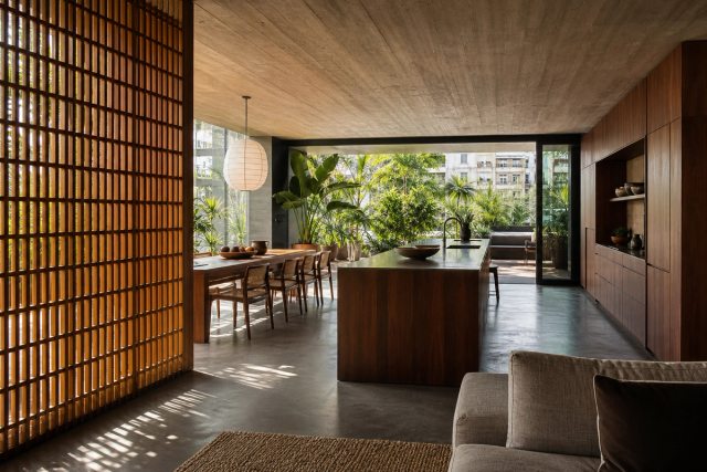 Fadior Milan 120 sqm Kitchen Penthouse — Milan penthouse kitchen with island, cabinet wall, concrete floor, hardwood lattice, dining table, and courtyard plants