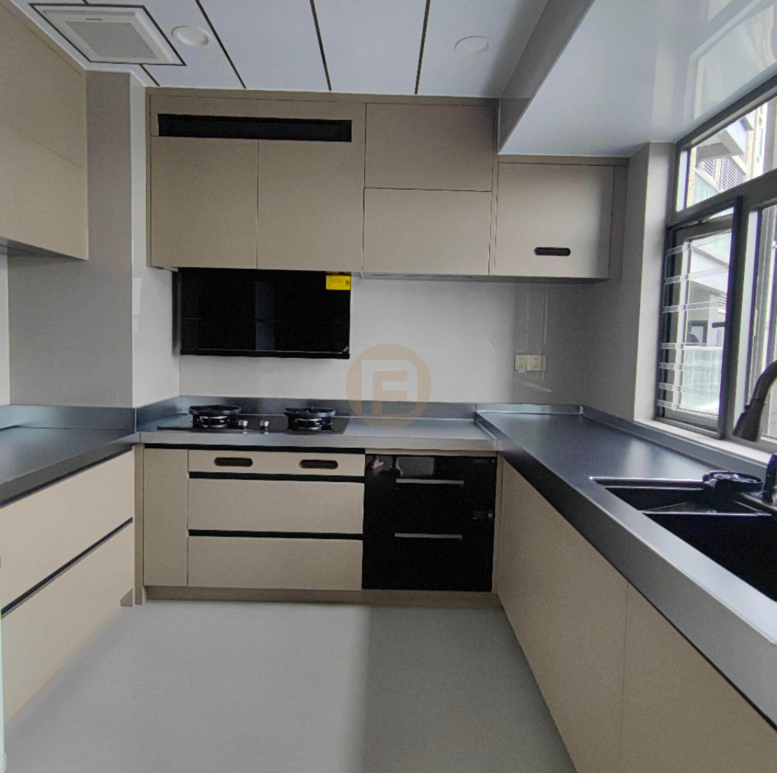 Greige 304 stainless steel kitchen with continuous stainless worktop, black appliances and corner window