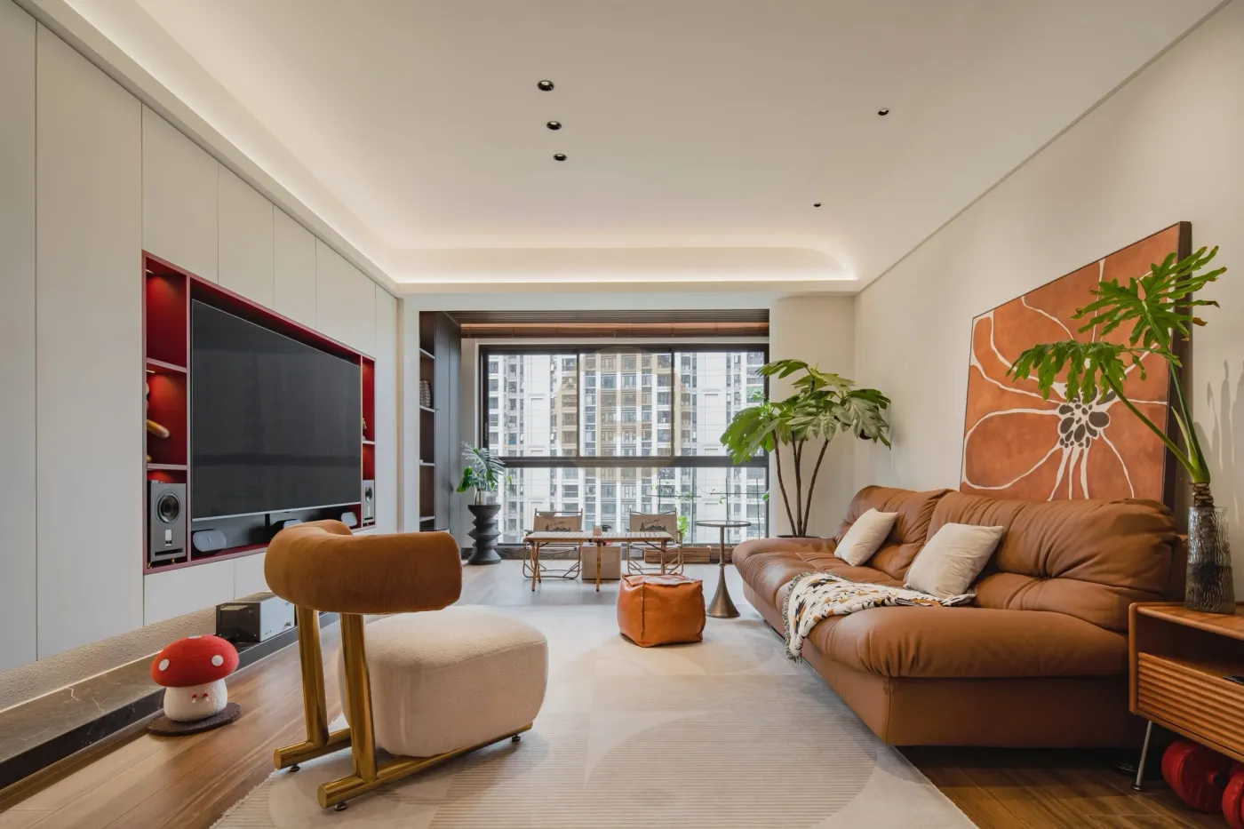 Cream living room with recessed TV-wall cabinetry, caramel leather sofa and warm abstract artwork