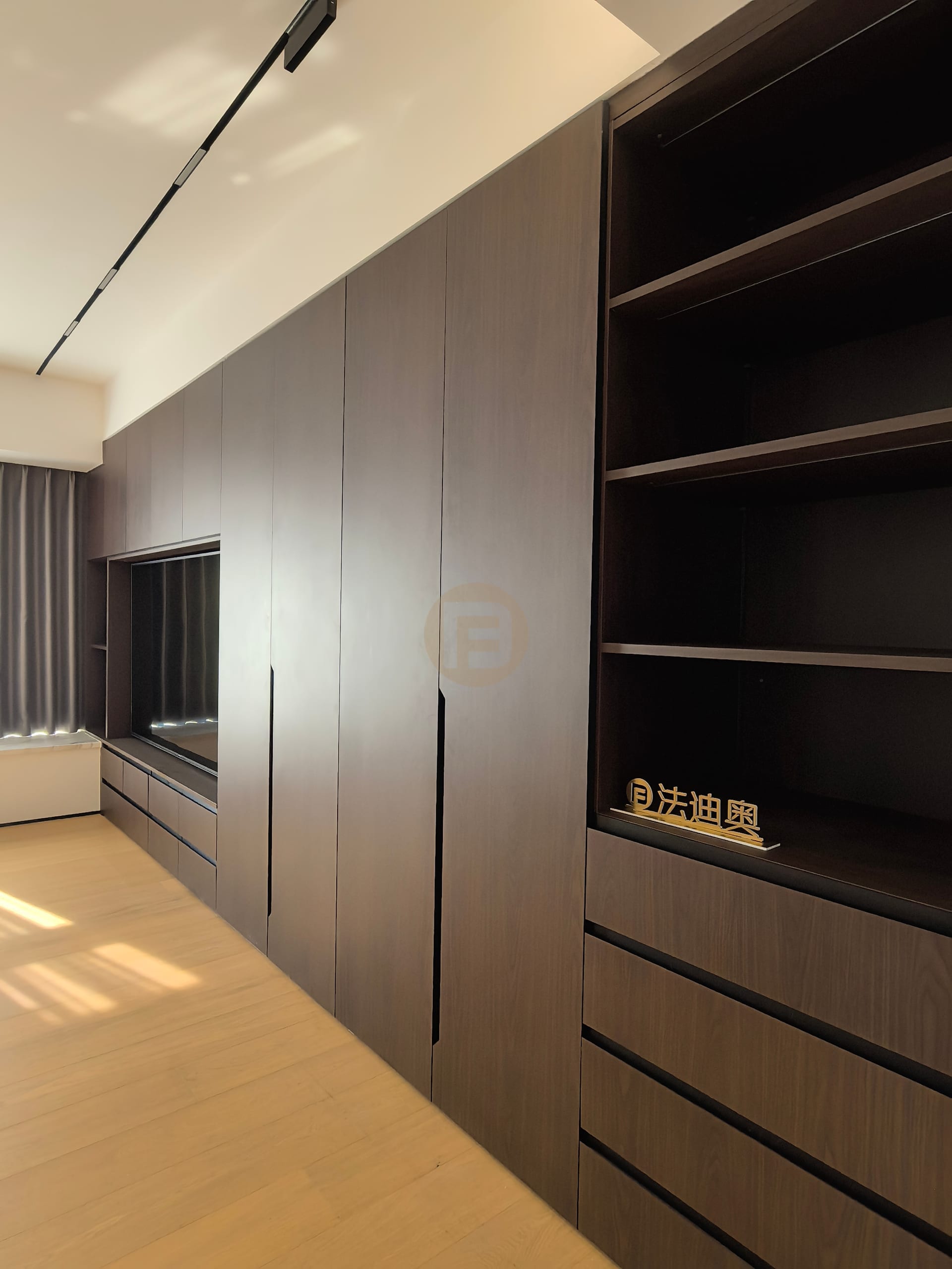 Walnut-toned stainless steel wardrobe wall with recessed media niche and open shelving