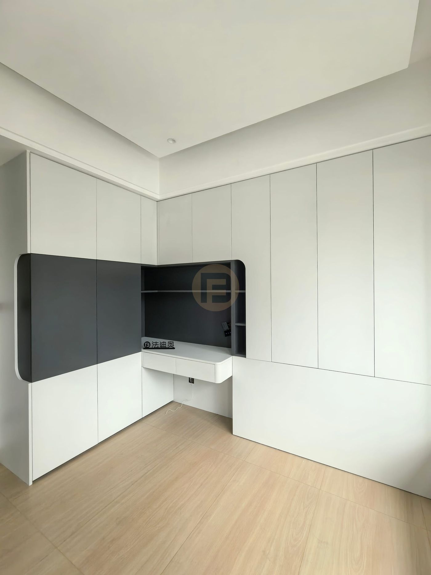 White cabinetry wall opening into a charcoal grey study niche with floating desk and open shelves