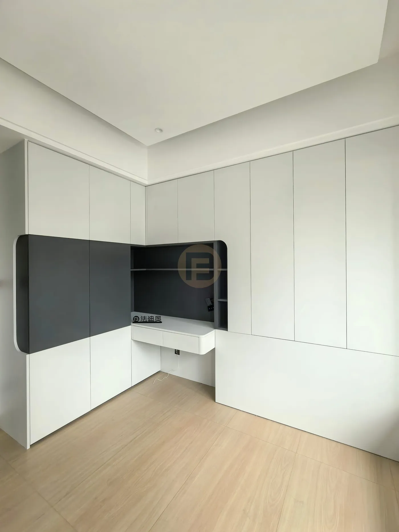 White cabinetry wall opening into a charcoal grey study niche with floating desk and open shelves