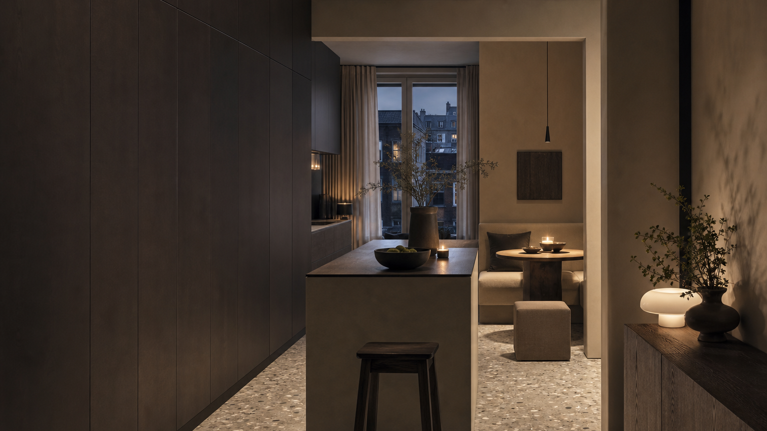 Compact city kitchen with espresso storage wall, slim island, and warm dining alcove at dusk.