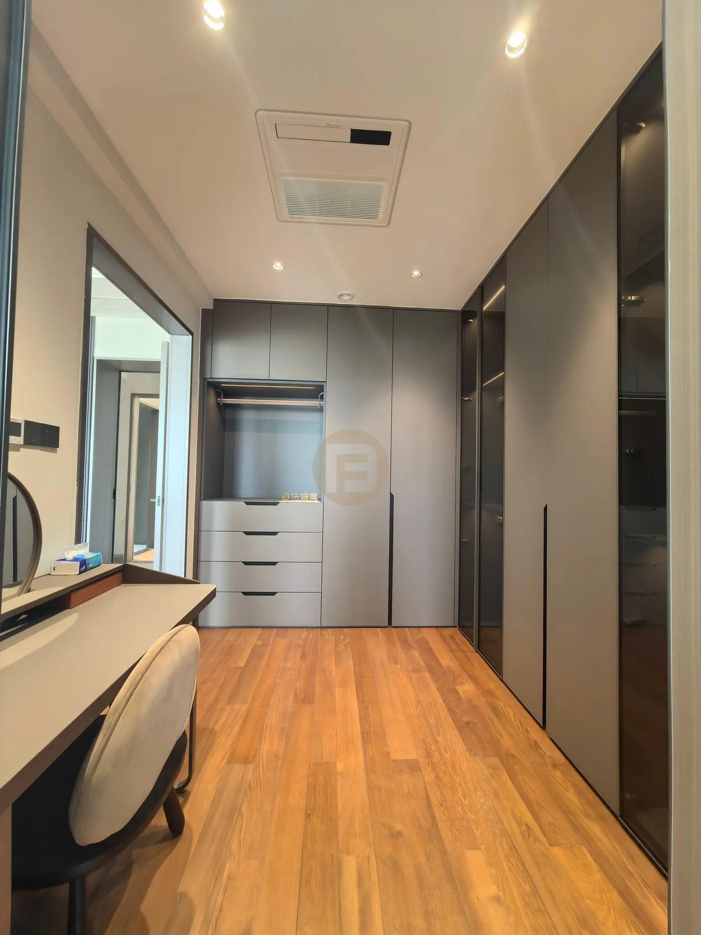 Dressing room with vanity desk, mirror and floor-to-ceiling wardrobes in two grey tones