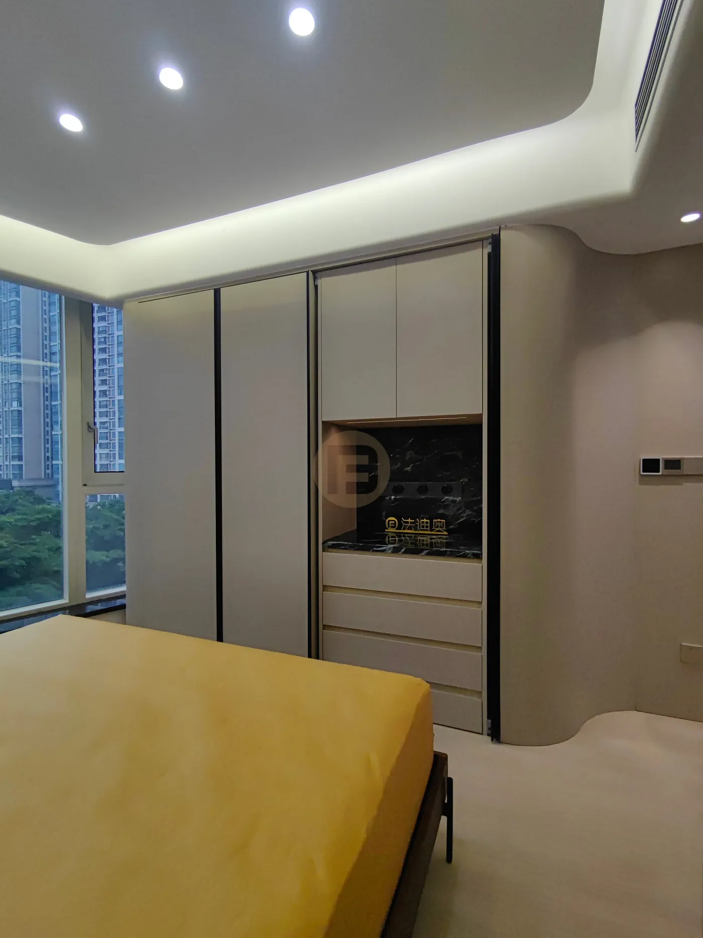 Bedroom wardrobe wall in warm greige stainless steel with a black marble dresser niche