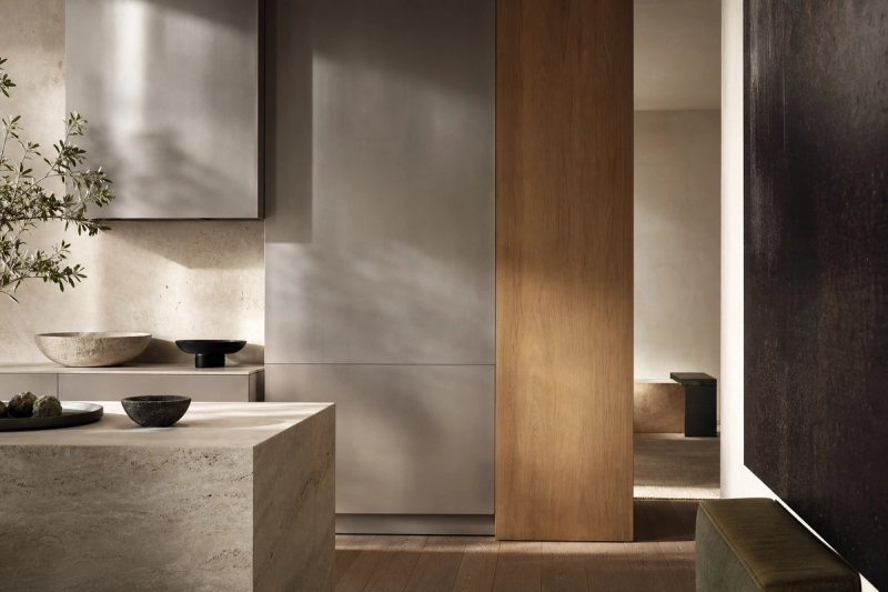 Material mood study: pale stone, warm oak-grain fronts, and smooth silver-toned cabinetry used to explain premium kitchen choices.