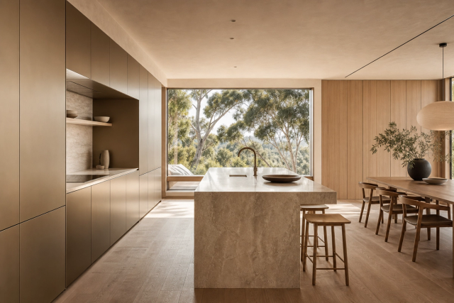 Fadior A Stainless Steel Kitchen That Remembers — champagne cabinet wall, stone island, oak dining table, timber floor, broad window, eucalyptus trees