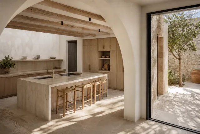 Fadior Jeddah 45 sqm Kitchen Villa — A full arched kitchen opens to a stone courtyard, with a pale island, timber cabinets,