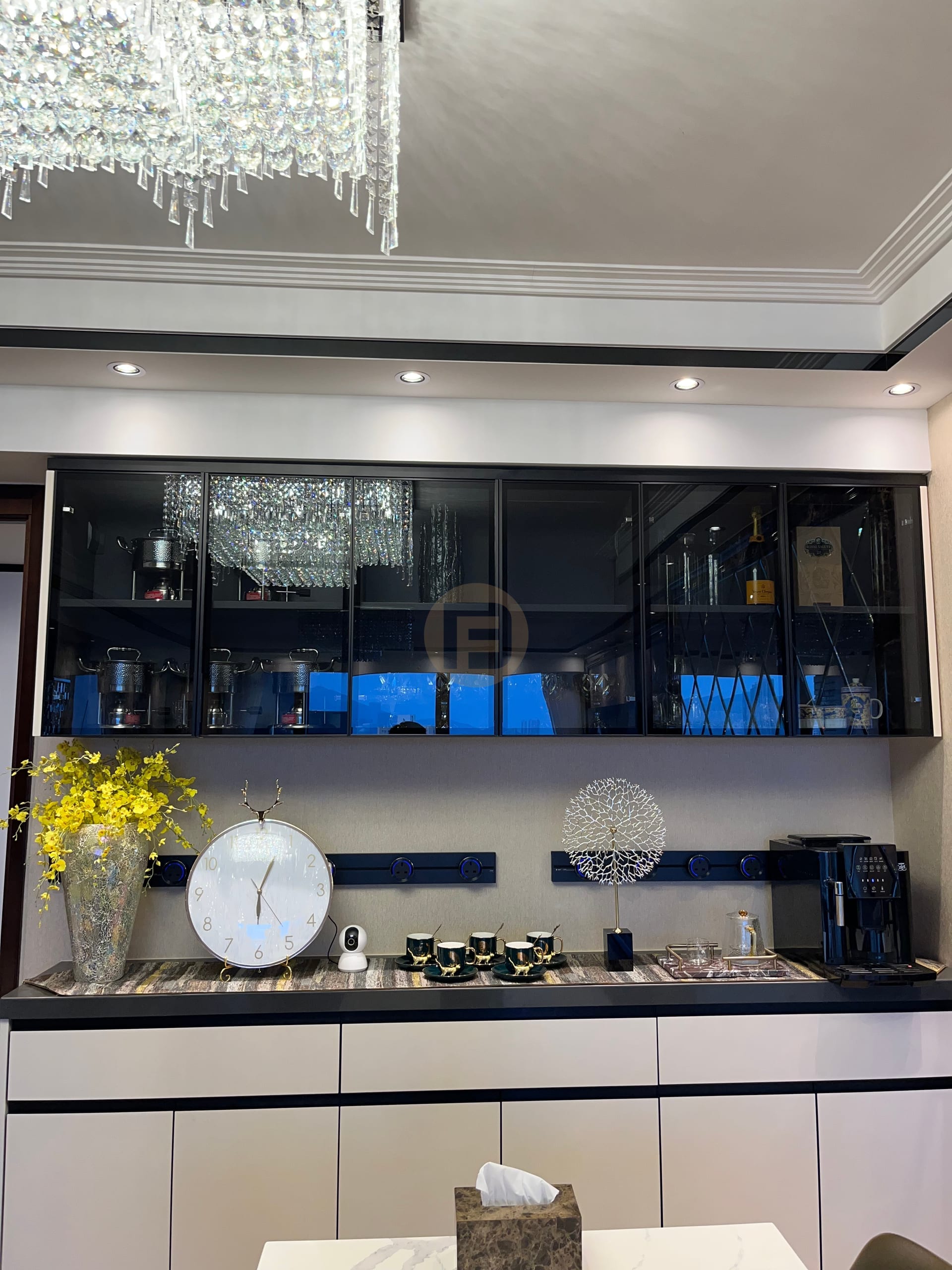 Smoked-glass upper cabinets and recessed power rail above the sideboard's serving counter