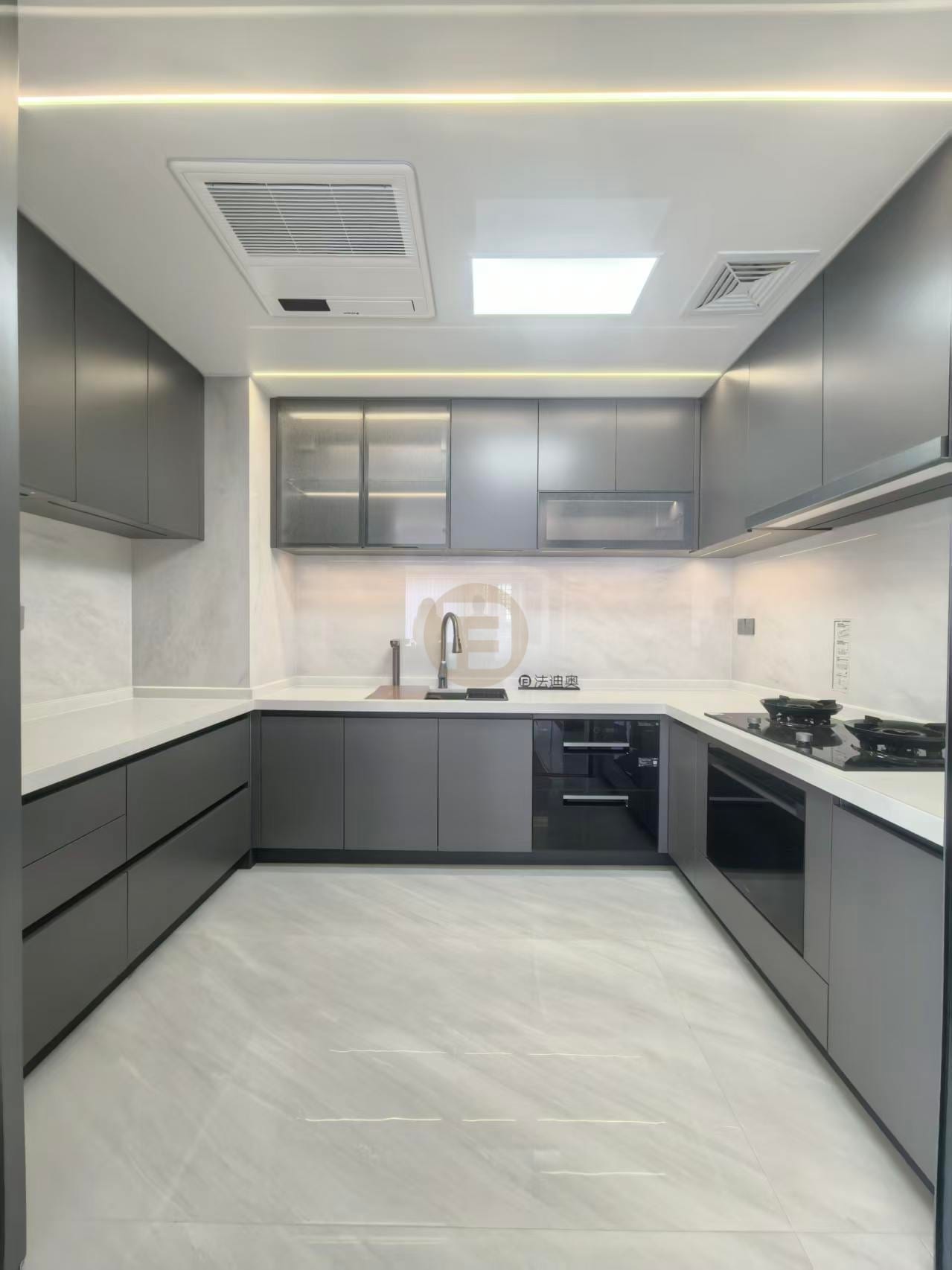 U-shaped kitchen with slate-grey stainless steel cabinetry, white stone worktops and glass-fronted upper cabinets