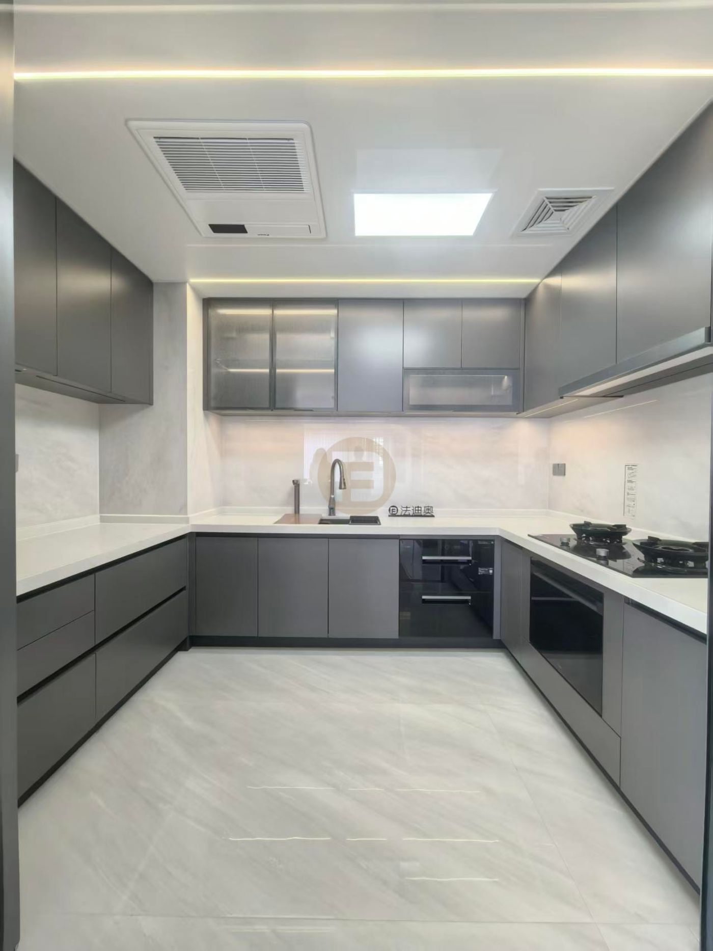 U-shaped kitchen with slate-grey stainless steel cabinetry, white stone worktops and glass-fronted upper cabinets