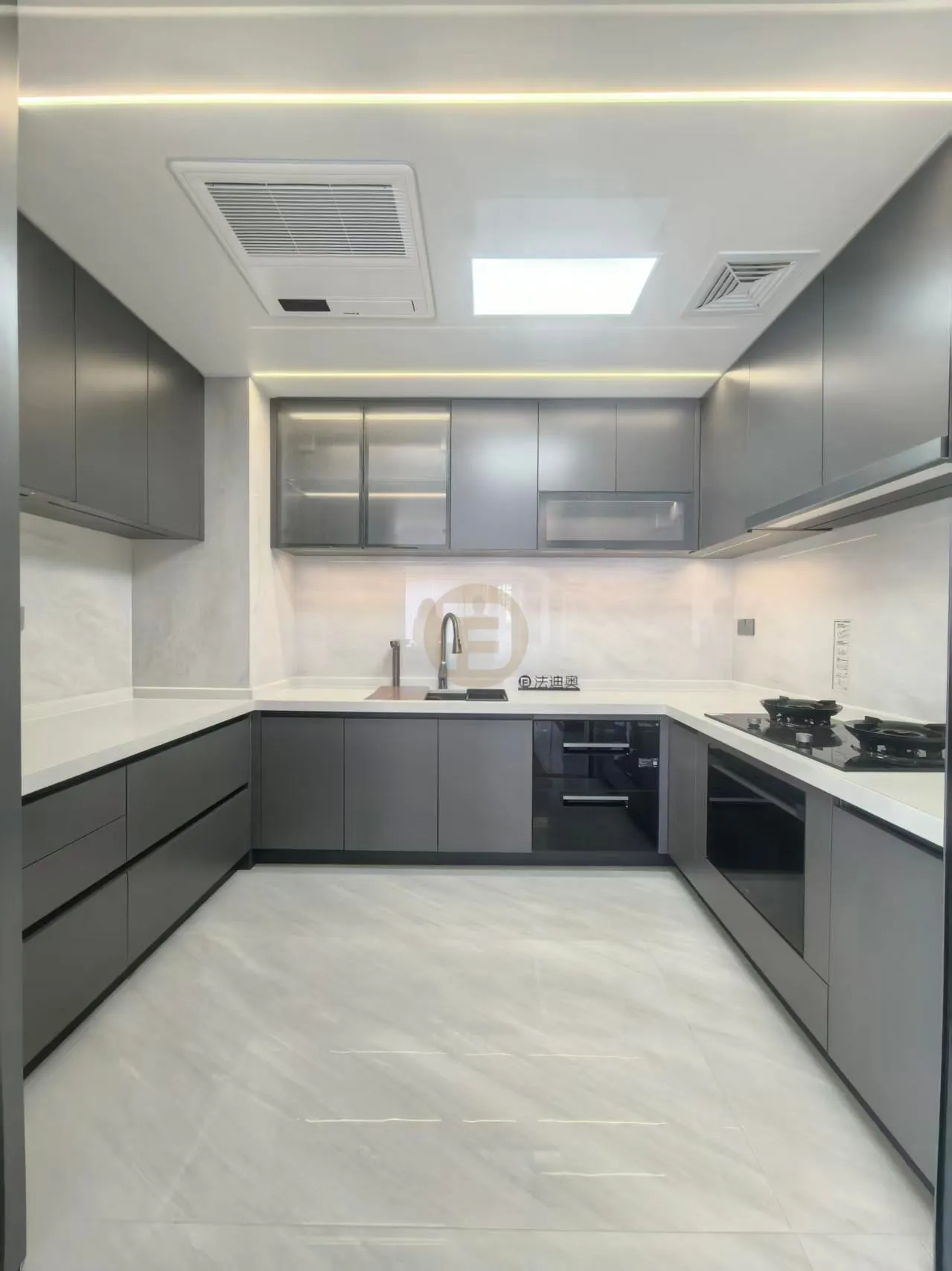 U-shaped kitchen with slate-grey stainless steel cabinetry, white stone worktops and glass-fronted upper cabinets