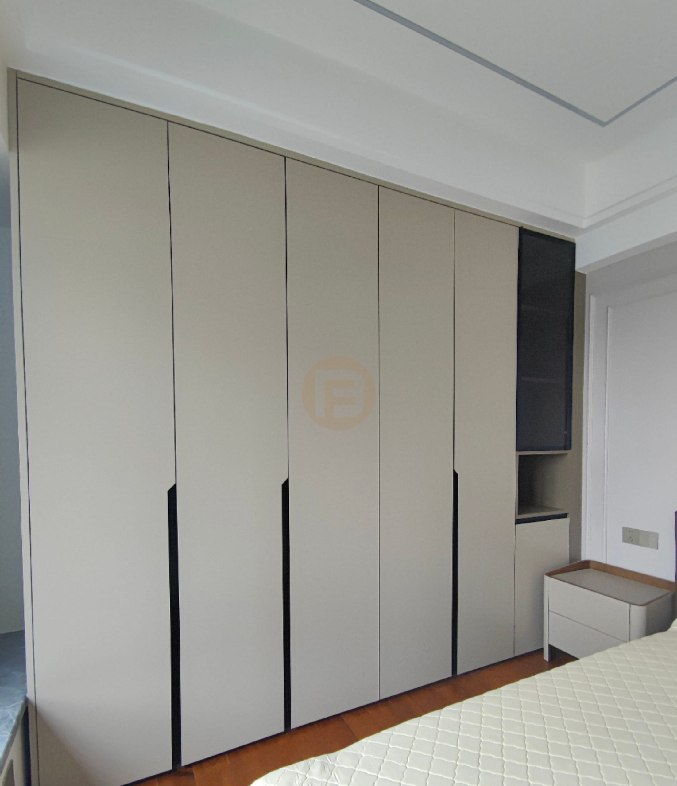 Floor-to-ceiling greige stainless steel wardrobes with recessed pulls and a smoked-glass display column in the bedroom