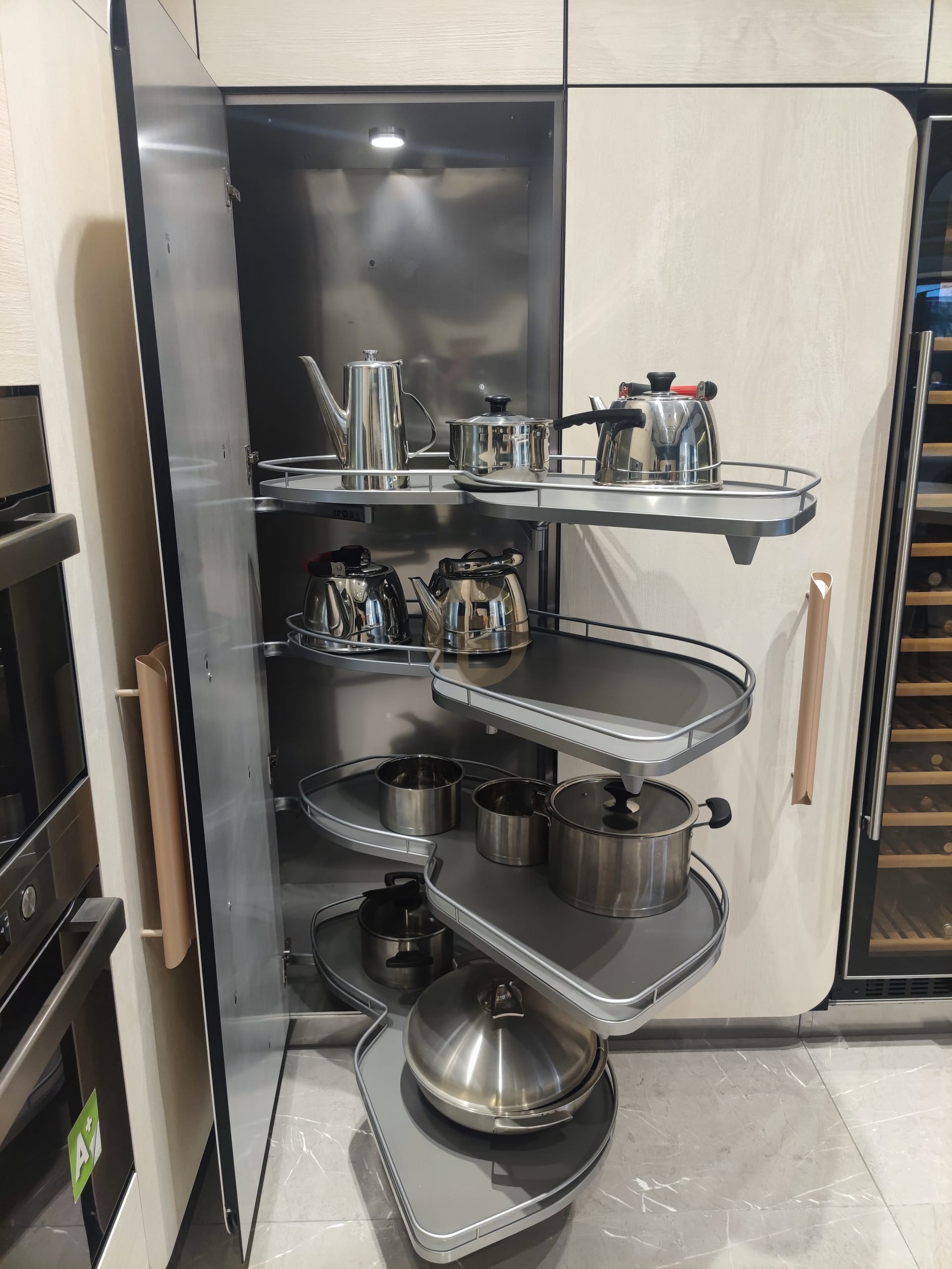 Pull-out corner carousel swinging steel-railed storage trays out of the blind cabinet