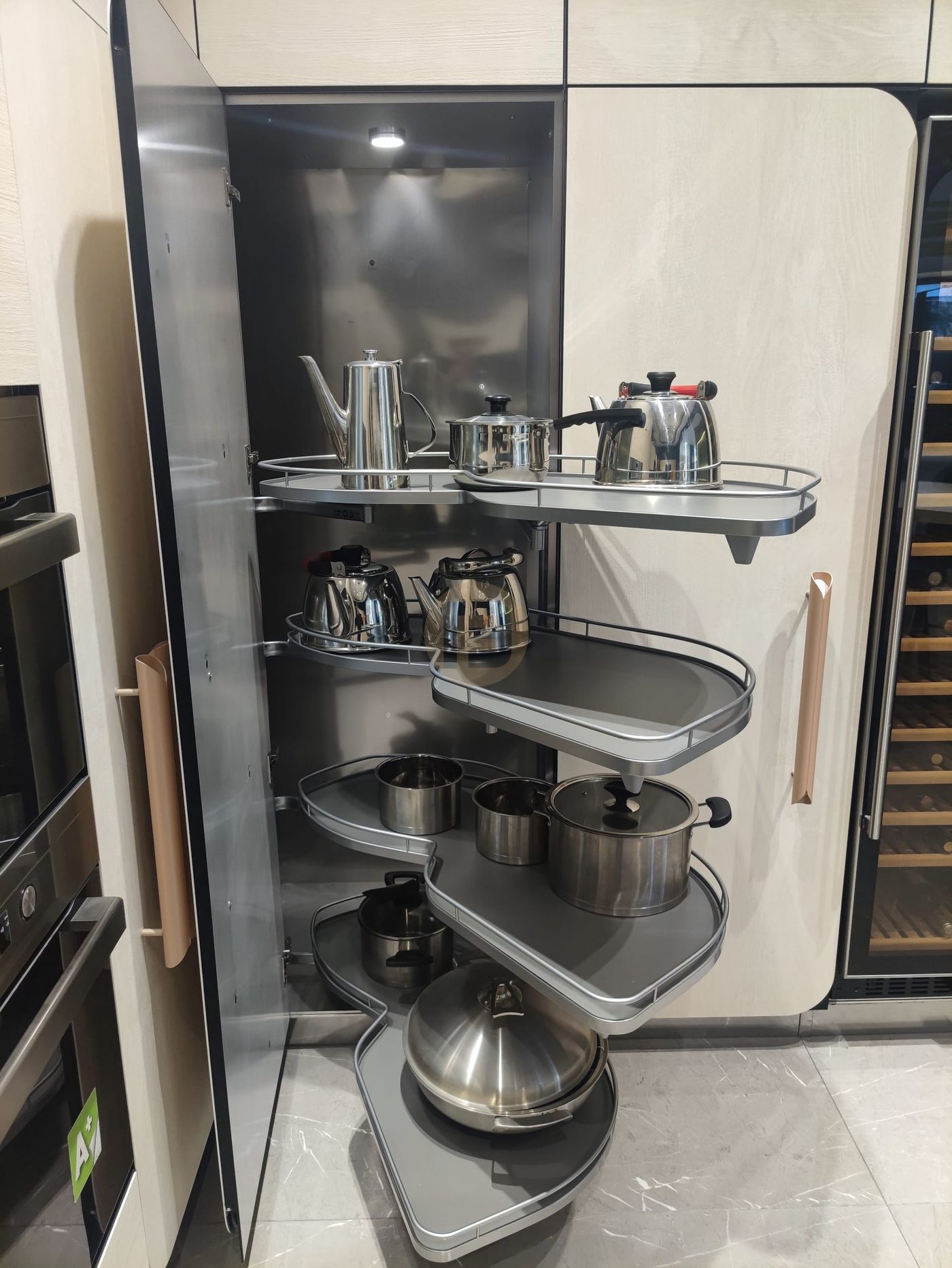 Pull-out corner carousel swinging steel-railed storage trays out of the blind cabinet