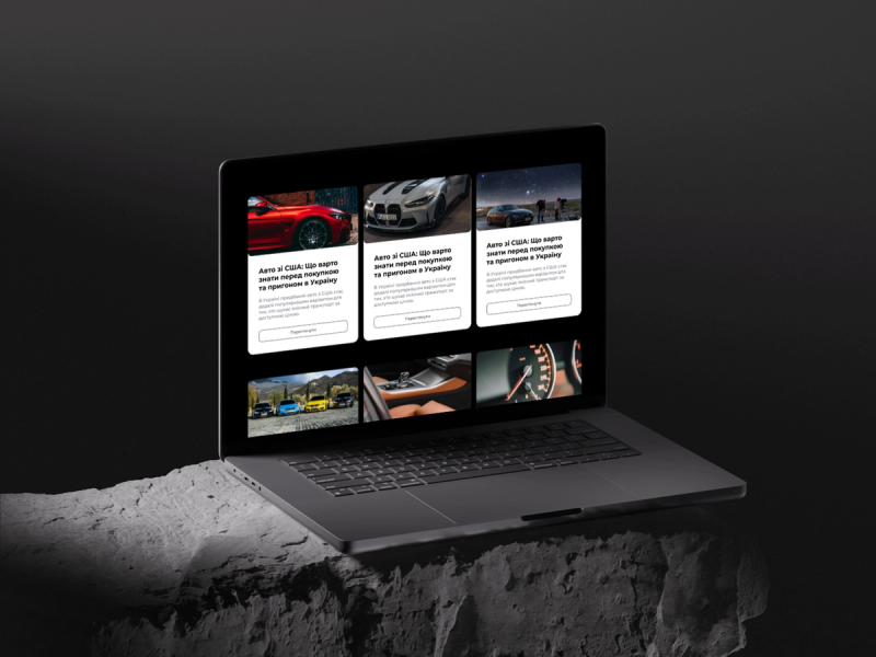Blog section with Ukrainian-language articles about importing cars from the USA, shown on a laptop