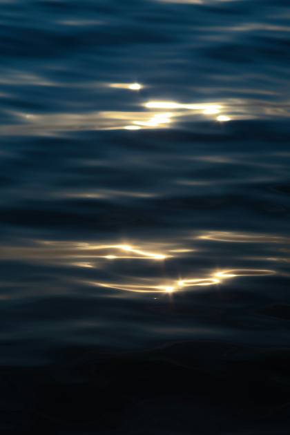 Sunlight glinting on dark, rippling water
