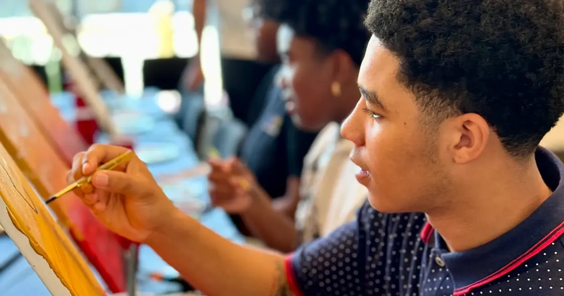 Young people painting at easels during a community art workshop