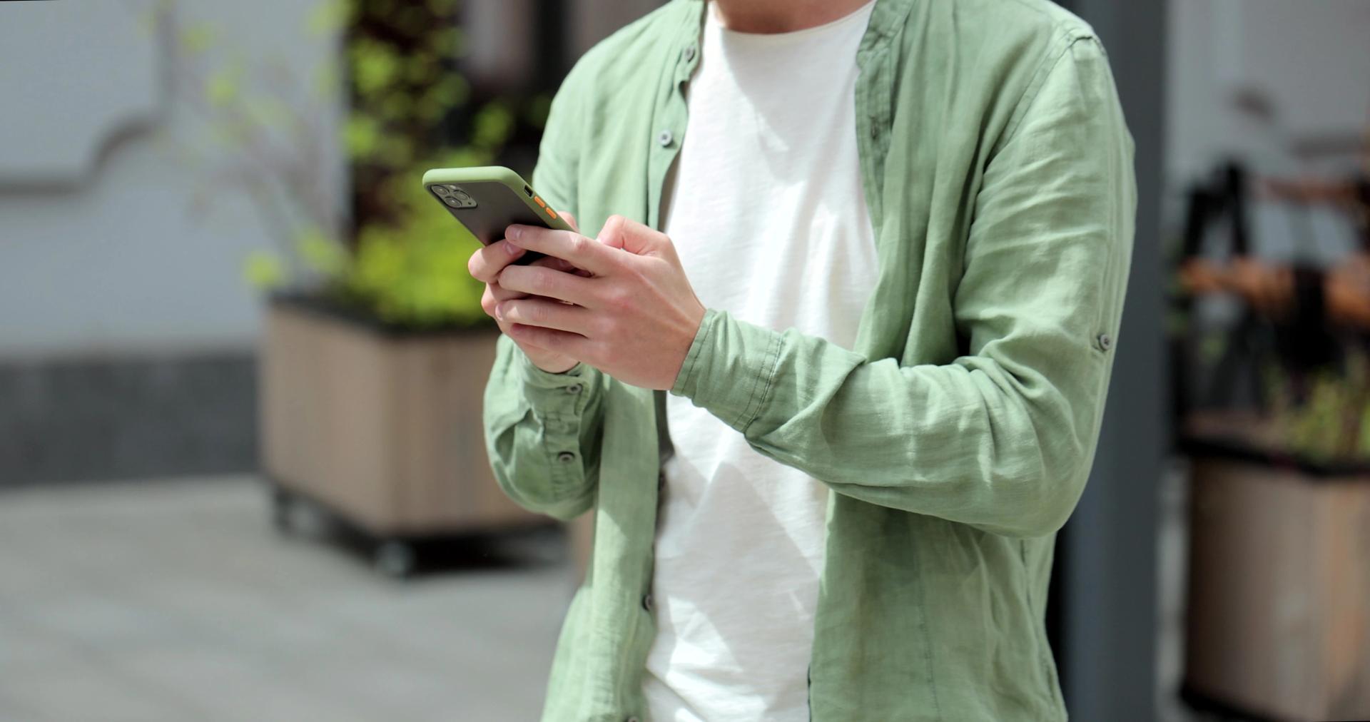 Person checking their smartphone eSIM compatibility on a city street