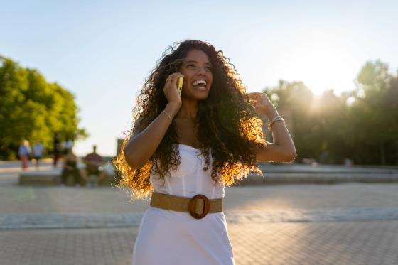 Woman talking on the phone outdoors at sunset