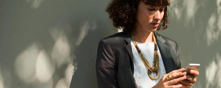 Woman in a blazer checking her phone