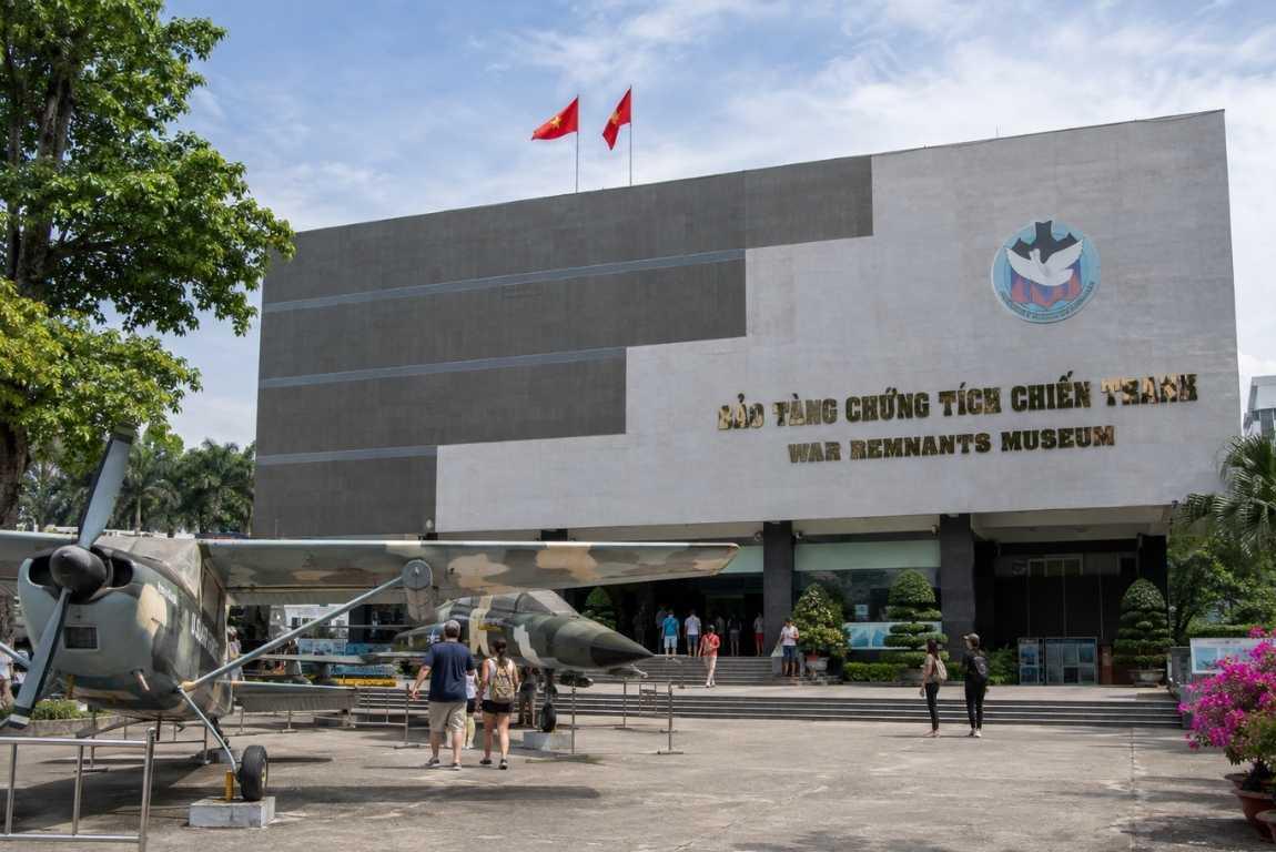 Exterior of the War Remnants Museum in Ho Chi Minh City, Vietnam, with historic military aircraft displayed outside.