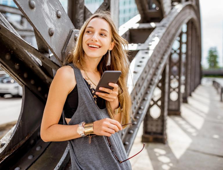 Traveler checking her phone while exploring a city