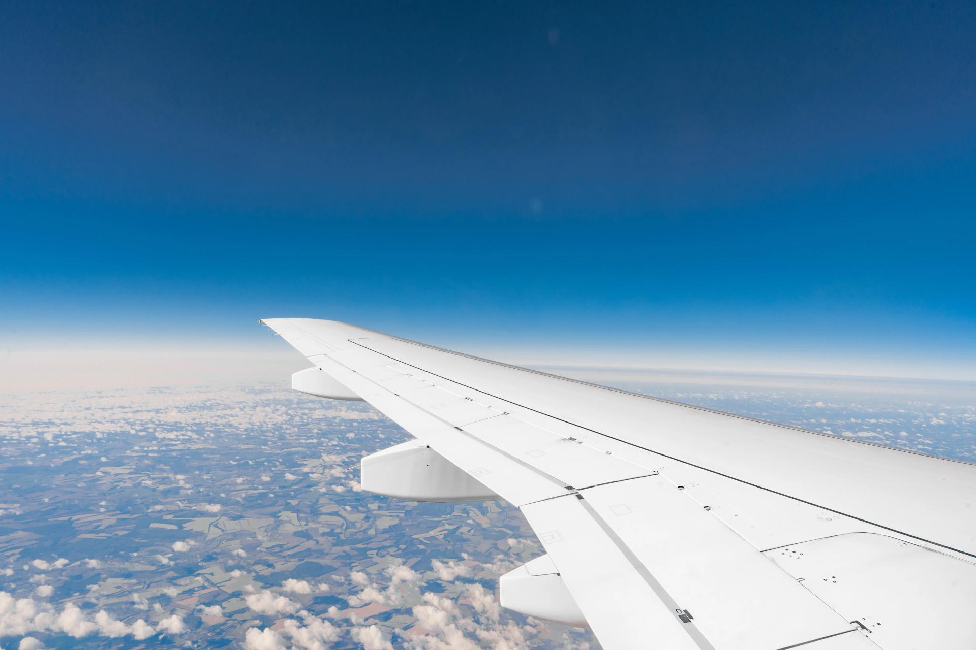 View of an airplane wing above clouds from a window seat