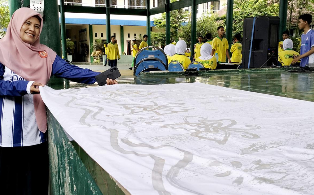 Pengrajin Batik TGP sedang mengerjakan dan menampilkan kain batik tulis khas Malangan di ruang produksi.