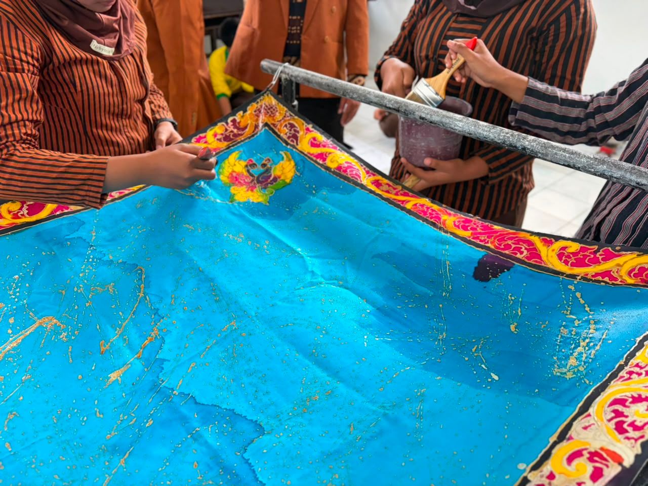 Proses penguncian warna batik menggunakan larutan waterglass.