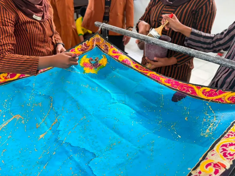 Proses penguncian warna batik menggunakan larutan waterglass.