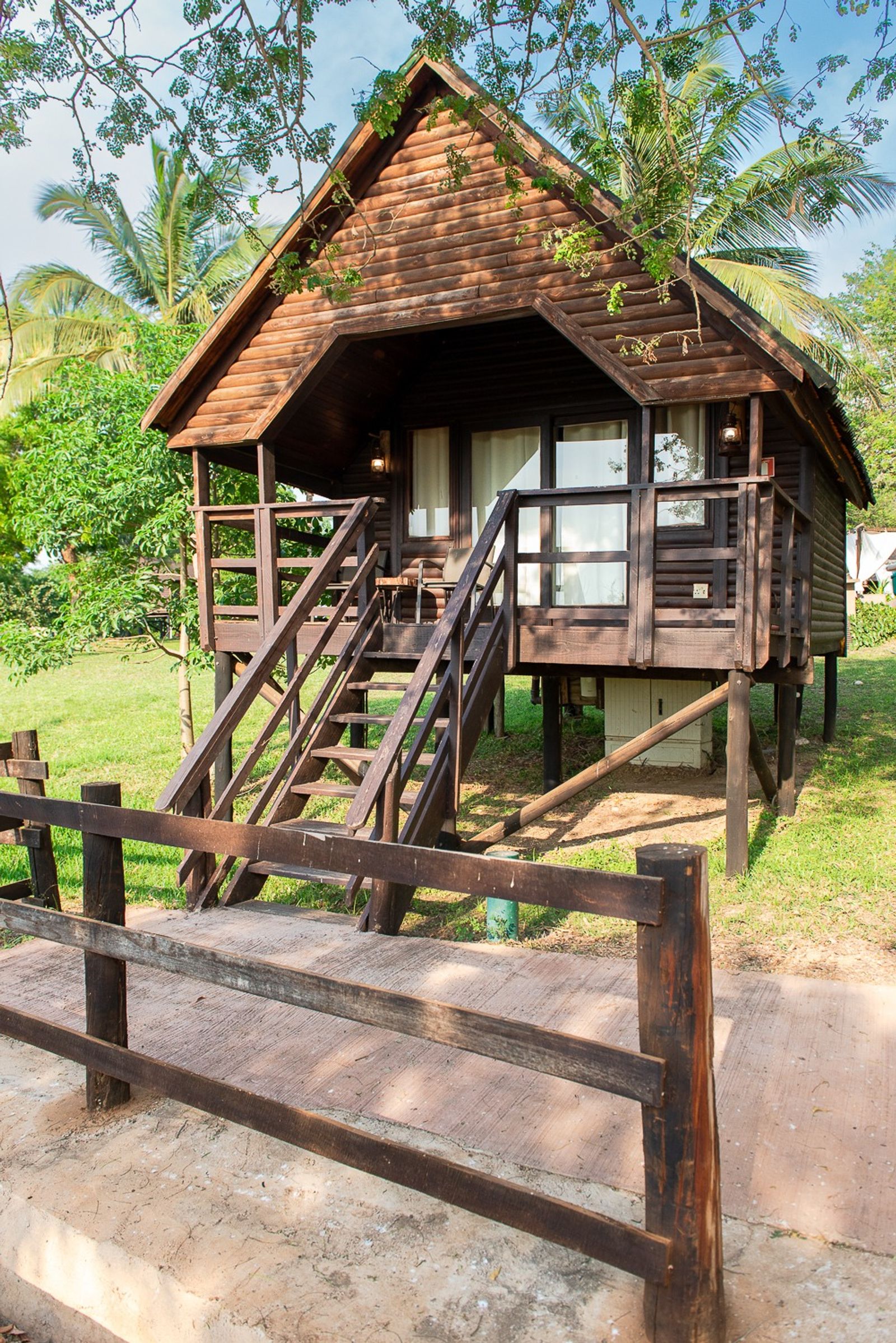 A-frame wooden cabana on stilts with steps up to its veranda
