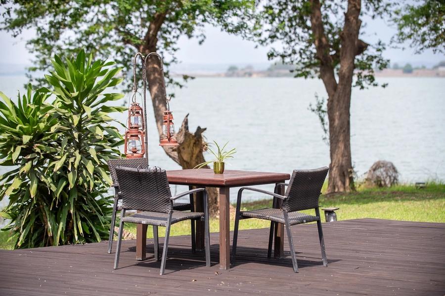 Table for two with lanterns on a wooden deck overlooking the Kilunda Lagoon