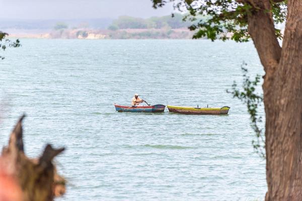 A man rowing a small boat on the Kilunda Lagoon, with a second boat alongside