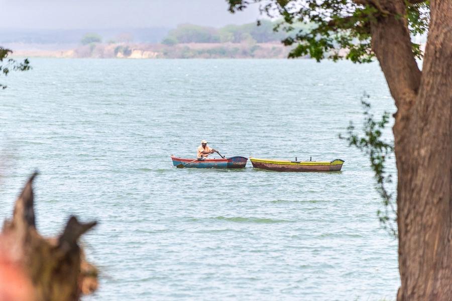 A man rowing a small boat on the Kilunda Lagoon, with a second boat alongside